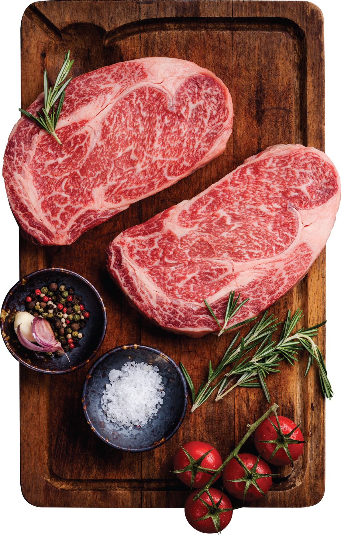 Premium marbled steaks with rosemary and salt on a wooden board